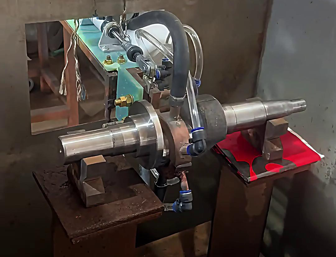 將曲軸置于中頻感應淬火設備中，通過感應線圈產生的交變磁場使曲軸表面迅速升溫至淬火溫度